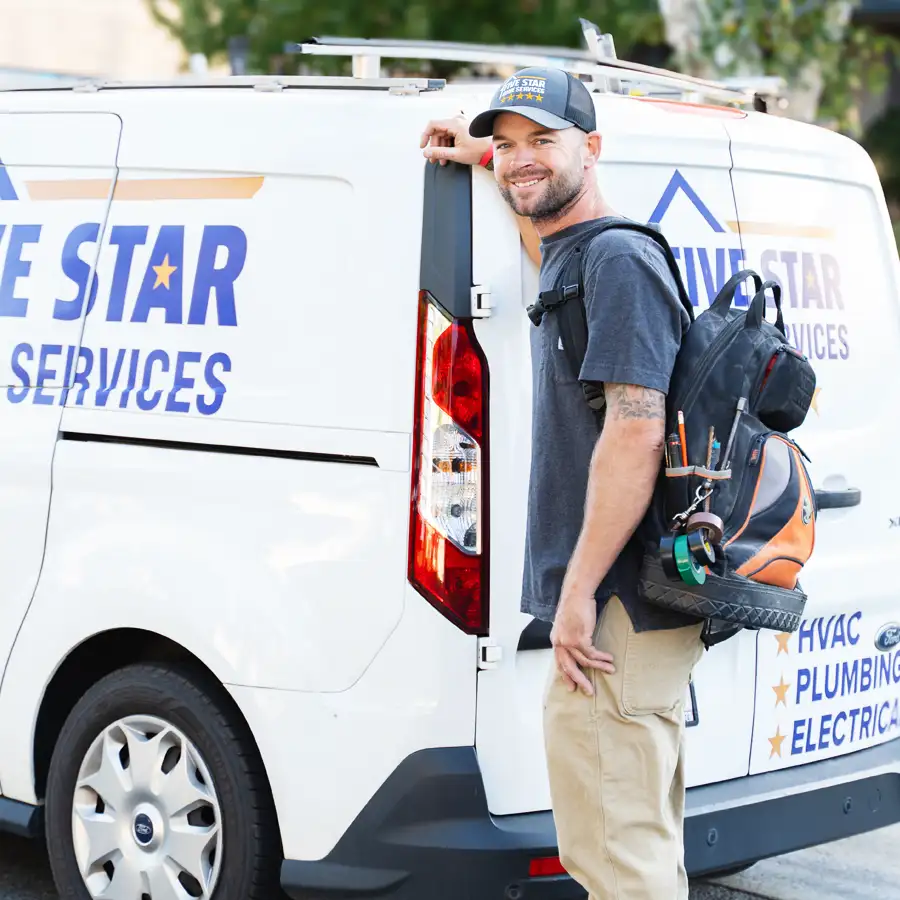 Plumber standing in front of a Five Star Home Services van