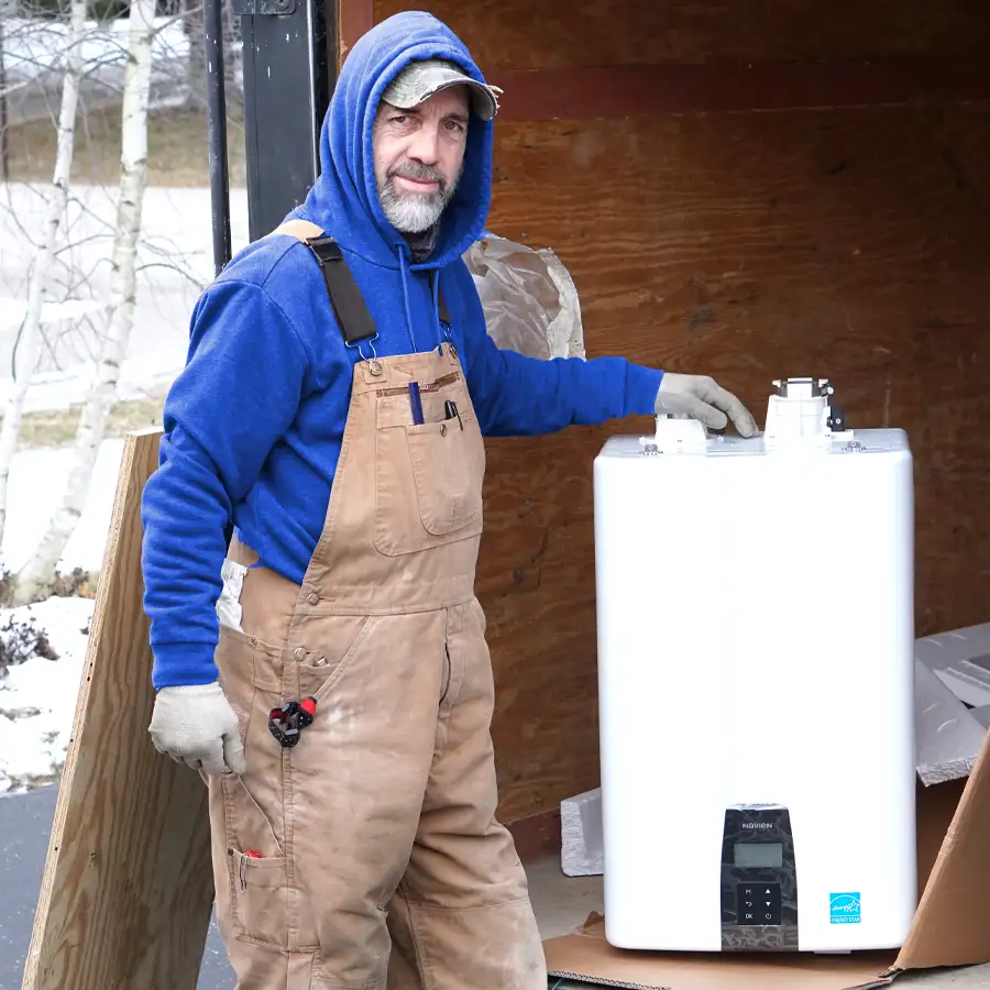 Plumber standing next to a tankless water heater