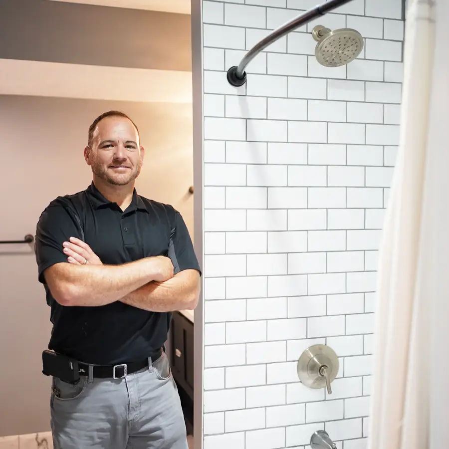 Plumber standing in front of a remodeled shower