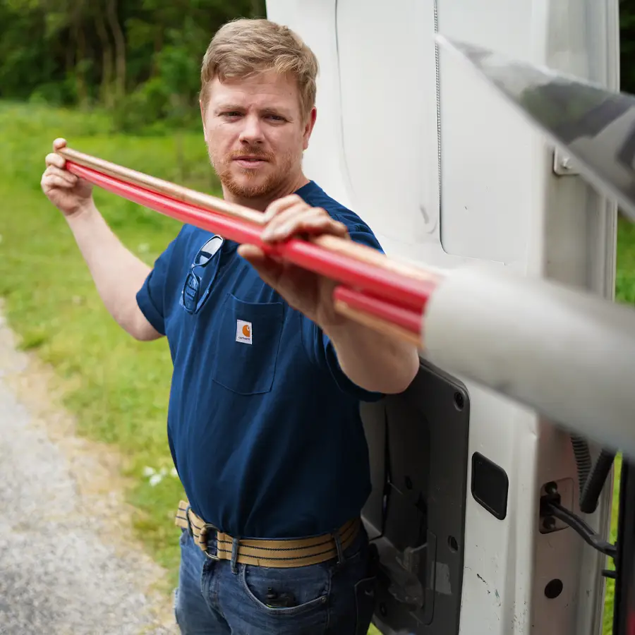 Plumber taking out plumbing pipes from his truck